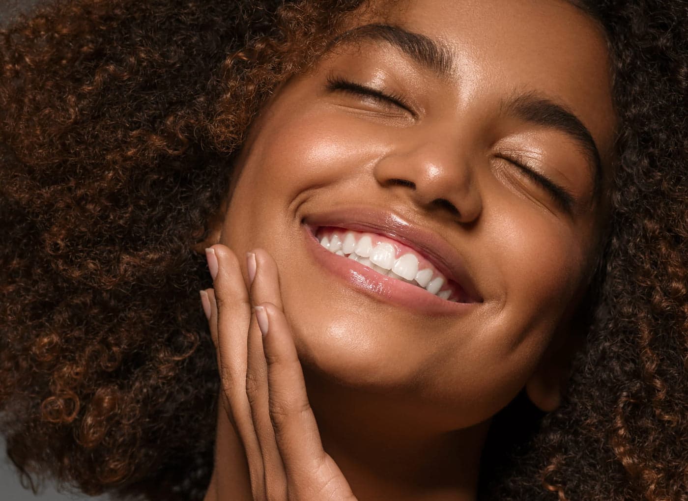 Close-up portrait of a woman smiling with her eyes closed