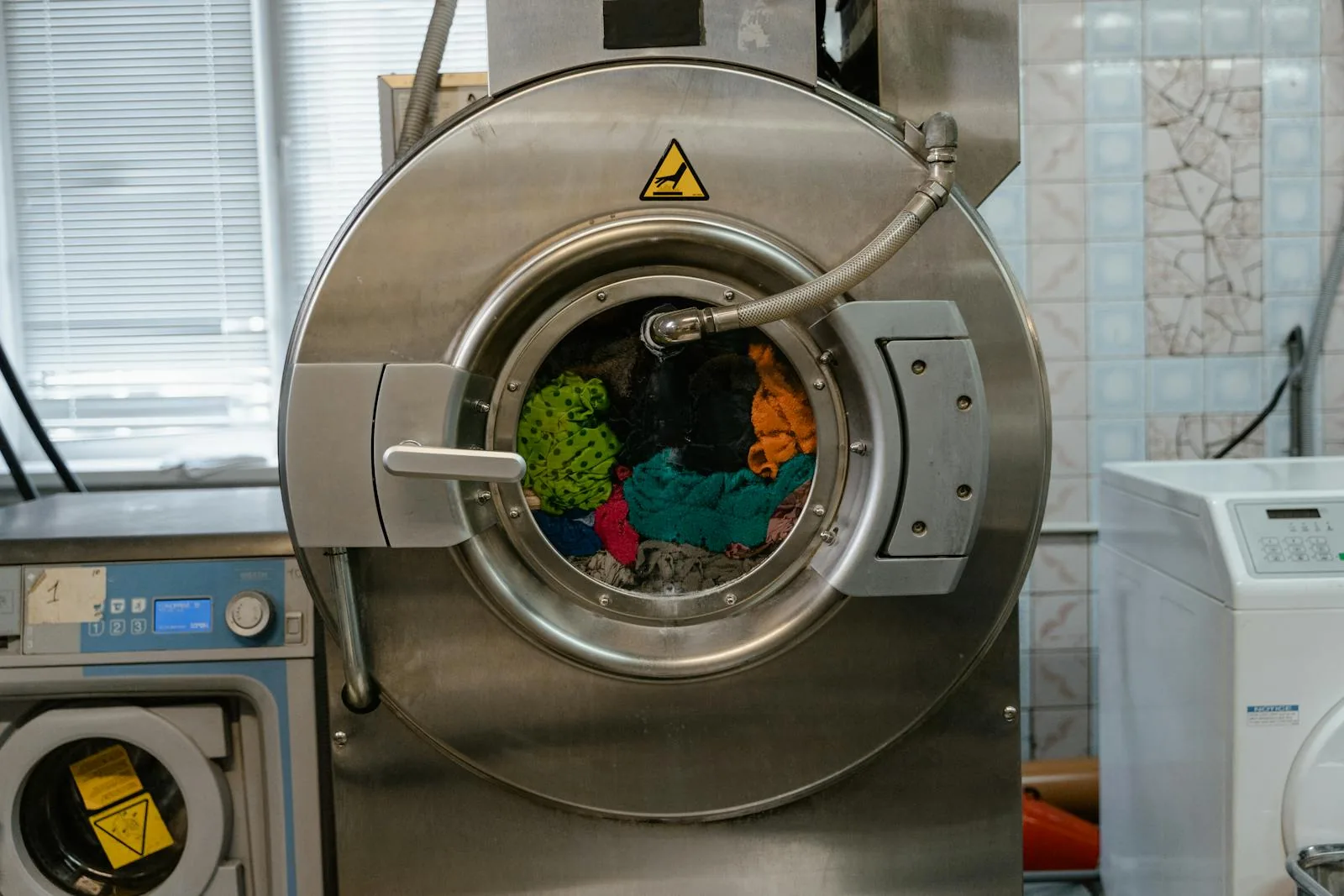 Clothes being washed inside a stainless-steel front-loading washing machine